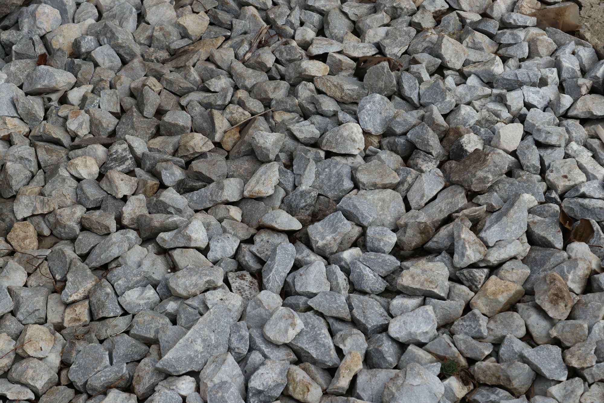 A sample of graded basalt aggregate photographed on a neutral ground.