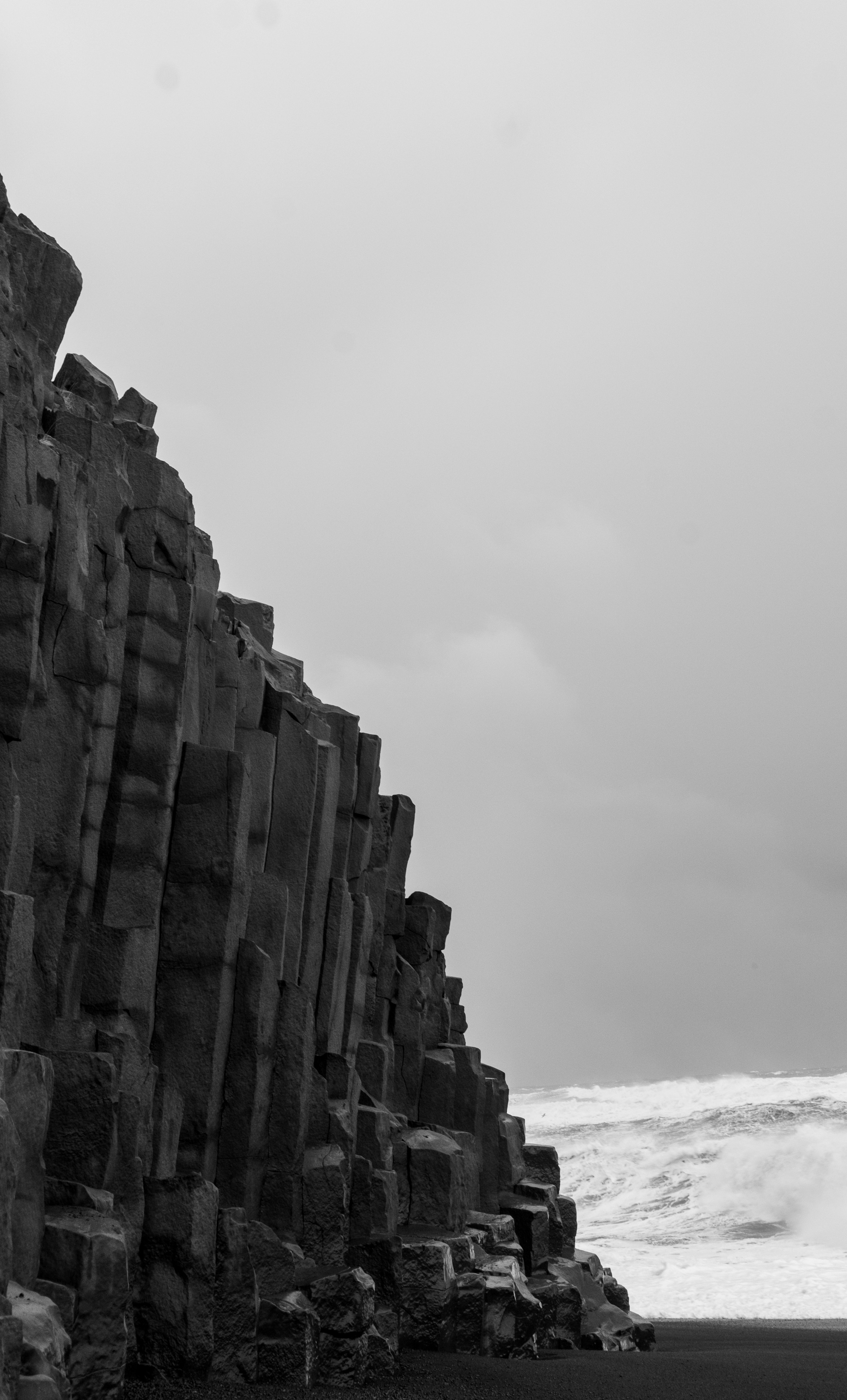 Basalt columns photographed in black and white against a flat pale sky.